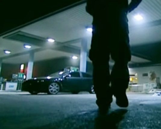 Mann an einer Tankstelle bei nacht.
