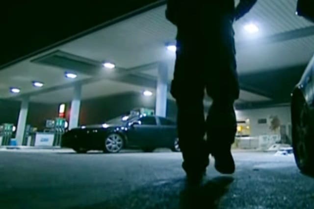 Mann an einer Tankstelle bei nacht.