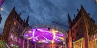 Das Hoepfner Burgfest in Karlsruhe. Eine große beleuchtete Bühne ist im Hintergrund zu sehen, davor befindet sich ein ebenso großes Publikum stehend aus tausenden Zuschauern.