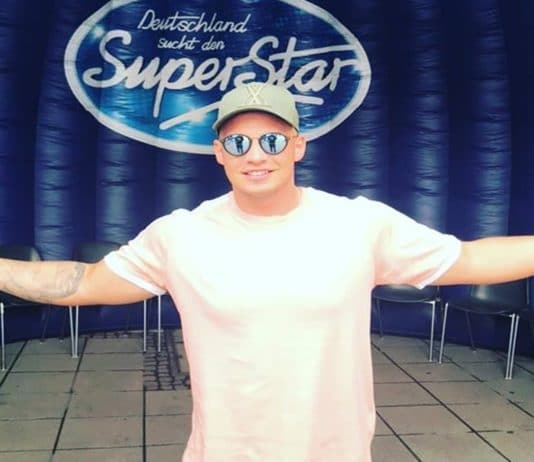 Pietro Lombardi bei DSDS auf einer kleinen Bühne vor dem berühmten blauen Logo der großen RTL-Show. Der Sänger trägt eine verspiegelte Sonnenbrille, Käppi und ein helles T-Shirt.