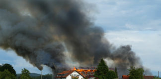 Bauernhof brennt lichterloh über dem Ort ist eine Rauchwolke zusehen
