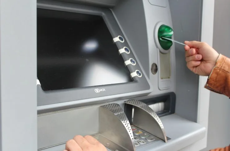 ec karte geldautomat sparkasse bank Bildschirm Tastenfeld abgeschirmt Hand Ein Mann steckt seine Geldkarte in einem Automaten, um Geld abzuholen. Man sieht den Bildschirm mit den Tasten und das abgeschirmte Zahlenfeld zur Eingabe der PIN.