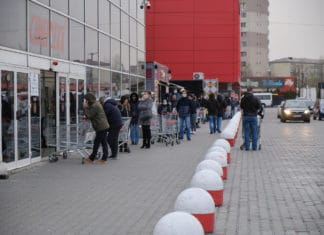 Lange Menschenschlange vor einem Supermarkt