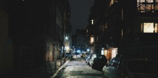 Straße nachts mit geparkten Autos