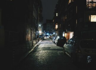 Straße nachts mit geparkten Autos