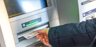 Person am Geld abheben am Bankautomaten