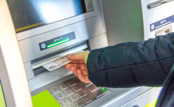 Person am Geld abheben am Bankautomaten