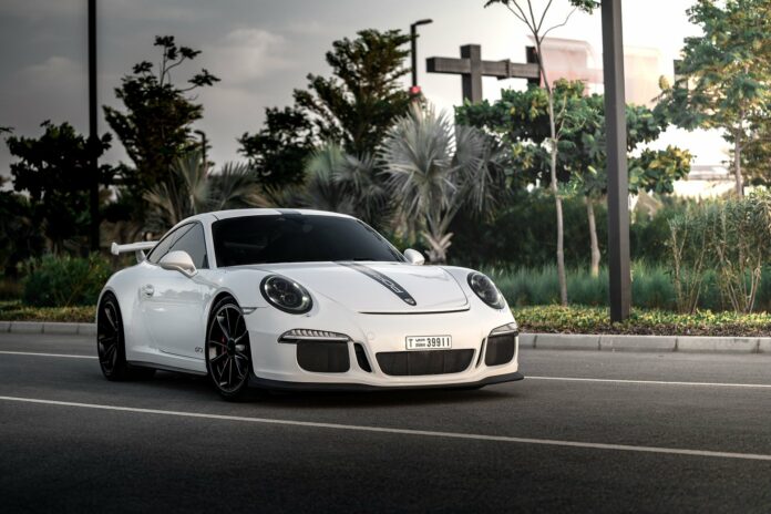 Ein weißer Porsche fährt auf der Straße.
