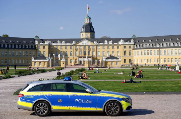 Karlsruhe Schlossgarten Schloss Garten Park Wiesen Wiese Grün Kultur Polizeifahrzeug Polizeiauto Karlsruher Schlossgarten mit Polizei. Ein Fahrzeug der Polizei steht im Park. Im Hintergrund bewegen sich die Gäste des Schlosses auf den breiten Wegen.