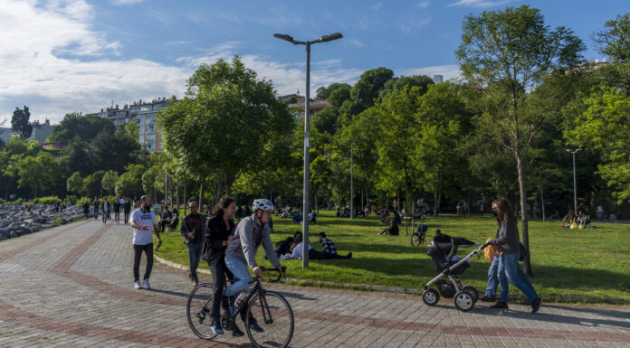 Menschen im Park mit Fahrrad und Kinderwagen