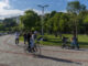 Menschen im Park mit Fahrrad und Kinderwagen