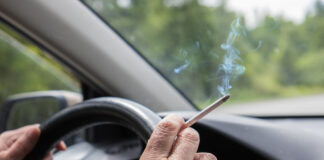 Person raucht im Auto
