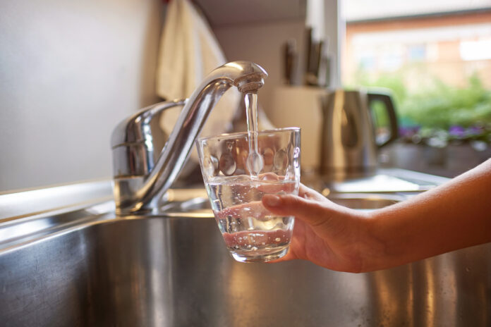 Trinken aus Wasserhahn.