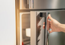 weibliche Hand öffnet Kühlschrank