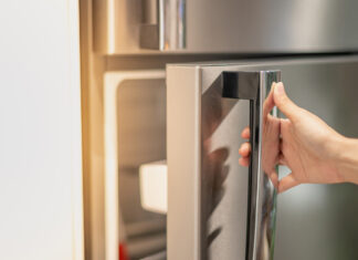 weibliche Hand öffnet Kühlschrank