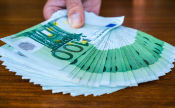 100 Euro Scheine in Hand. 20 Millionen Menschen erhalten mehr Geld.