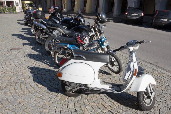 Motorräder und Mofas auf Straße geparkt