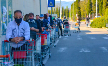 Eine lange Menschenschlange vor einem Supermarkt