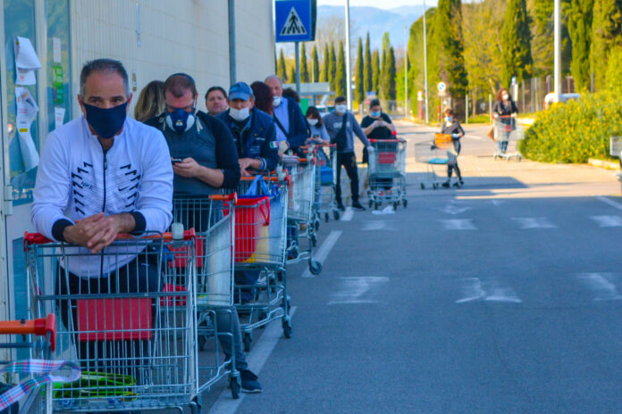 Eine lange Menschenschlange vor einem Supermarkt