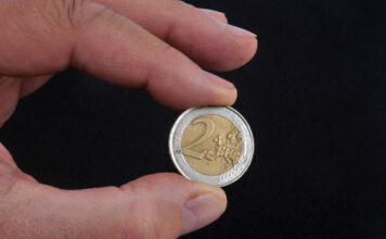 2 Euro Münze in Hand.