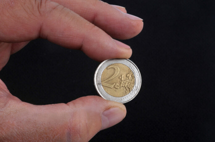 2 Euro Münze in Hand.