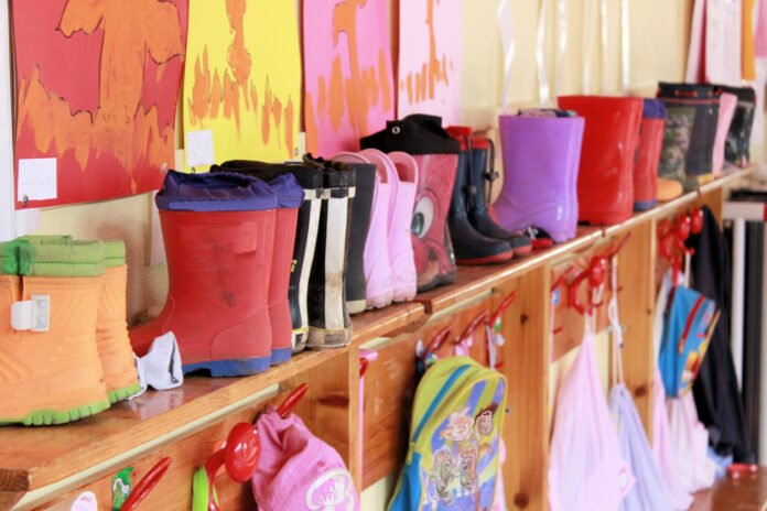 Eine Garderobe im Kindergarten mit Regenstiefeln und Rucksäcken