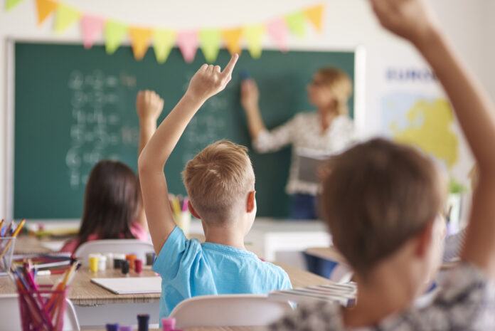 Lehrer im Klassenzimmer an Tafel