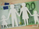 Eine Papierfamilie auf Geldscheinen.