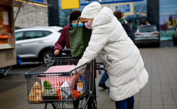 Frauen am Einkaufswagen am Supermarkt