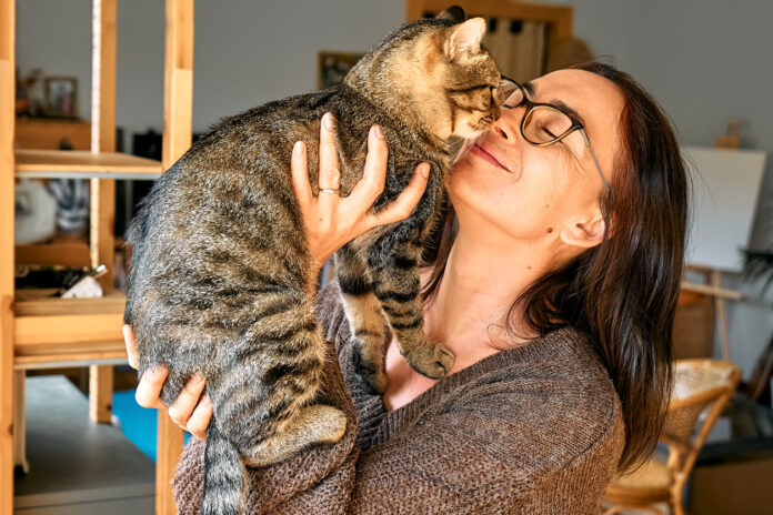 Frau schmust mit ihrer Katze
