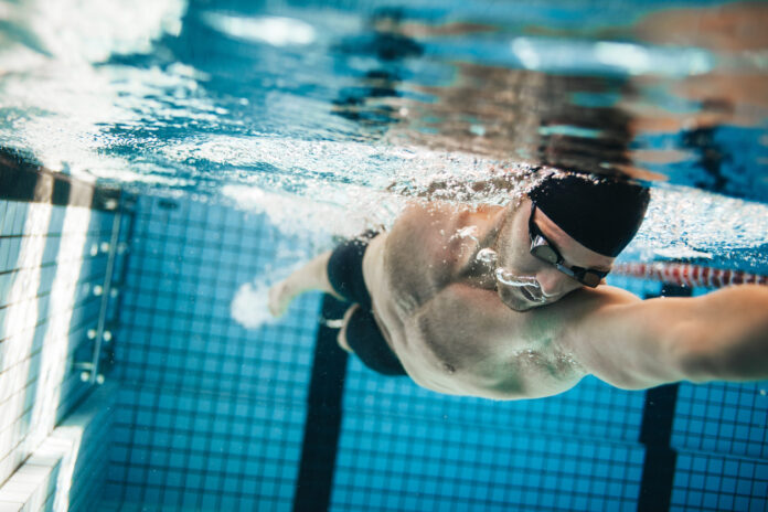 Ein Sportschwimmer trainiert im Hallenbad.