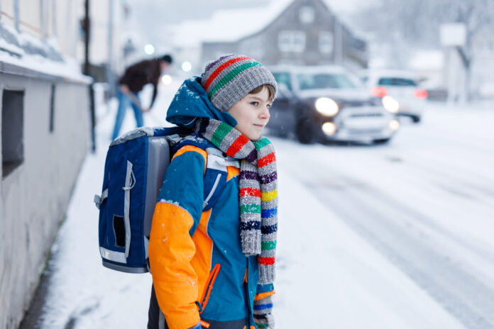 Kind auf dem Schulweg bei Schnee