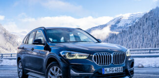 SUV von BMW steht vor einem Bergpanorama.
