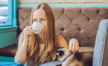 Eine Frau trinkt im Katzencafé einen Kaffee.