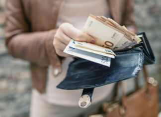 Eine Frau zählt Geld aus ihrem Geldbeutel.