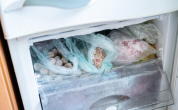 Ein geöffneter Gefrierschrank mit unterschiedlichen Paketen von gefrorenen Lebensmitteln.