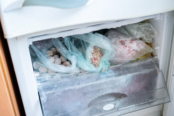 Ein geöffneter Gefrierschrank mit unterschiedlichen Paketen von gefrorenen Lebensmitteln.