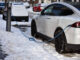 Ein E-Auto lädt am Straßenrand im Winter.