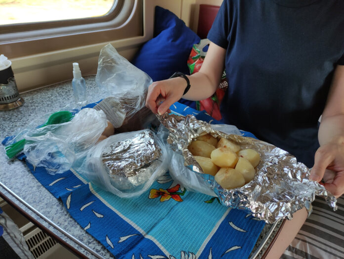 Ein Fahrgast in der Bahn isst zu Mittag.