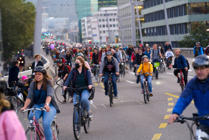 Radfahrer demonstrieren für bessere Radwege. Zahlreiche Menschen sind auf ihren Fahrrädern unterwegs auf den Straßen durch die Innenstadt. Es ist kein Auto weit und breit zu sehen.