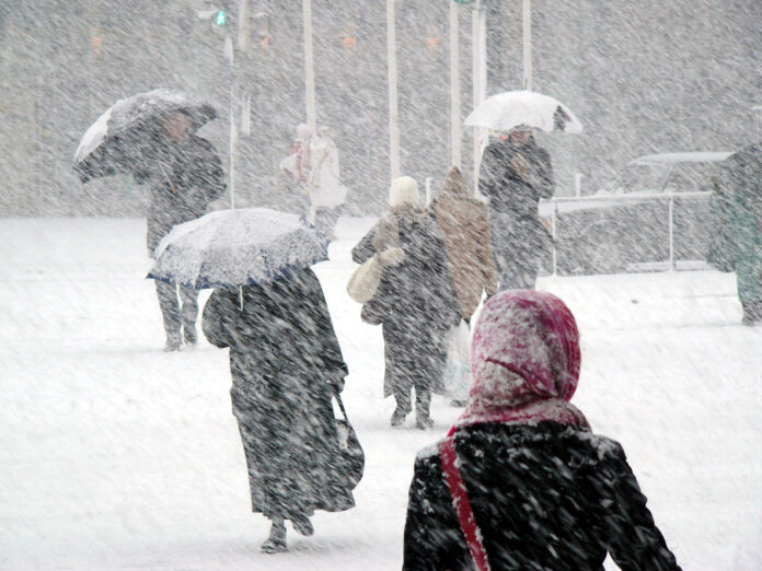 Menschen gehen im Schneesturm.