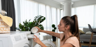 Frau befüllt ihre Waschmaschine.
