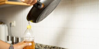 Öl wird aus einer Pfanne in eine Flasche gegossen.