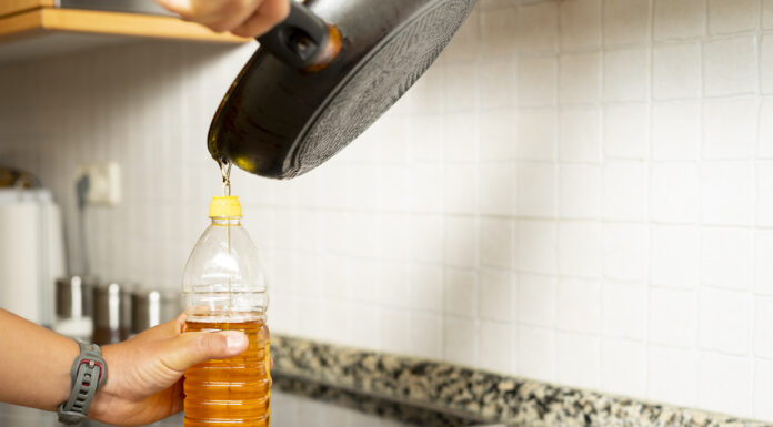 Öl wird aus einer Pfanne in eine Flasche gegossen.