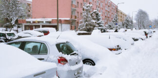 Parkende Autos sind vom Schnee bedeckt.
