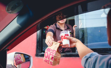 Ein Mann erhält seine Bestellung im McDonald's Drive in.