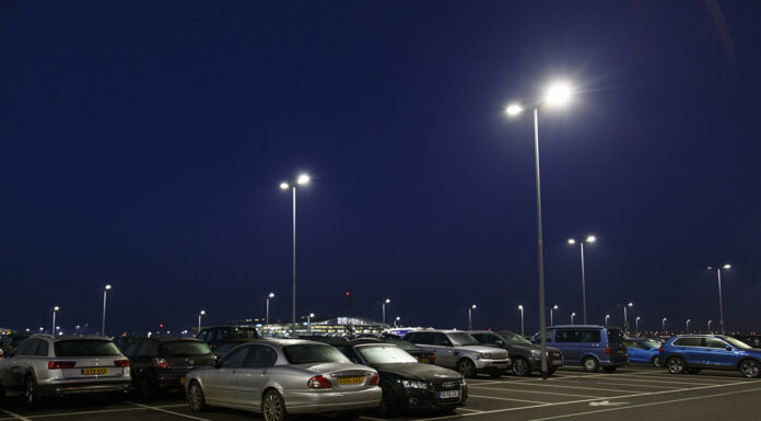 Autos parken nachts auf einem Parkplatz mit Straßenlaternen
