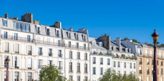 Häuserfassade in Paris mit Bäumen am unteren Bildrand