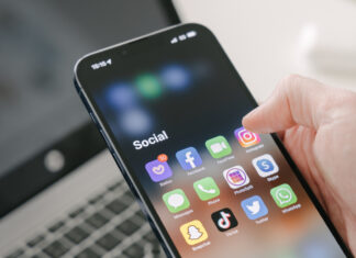 Ein Hand scrollt durch ein Smartphone und Social-Media-Apps
