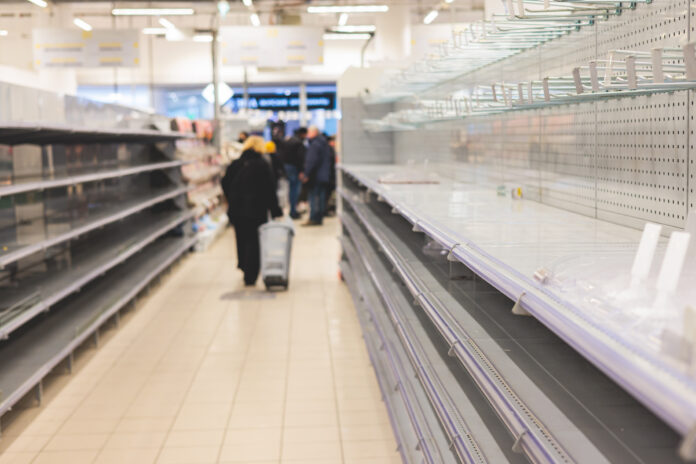 Kunden stehen vor leeren Regalen im Supermarkt.